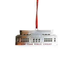 A metal holiday ornament in the shape of the New York Public Library building, with a silver finish, and a red ribbon.